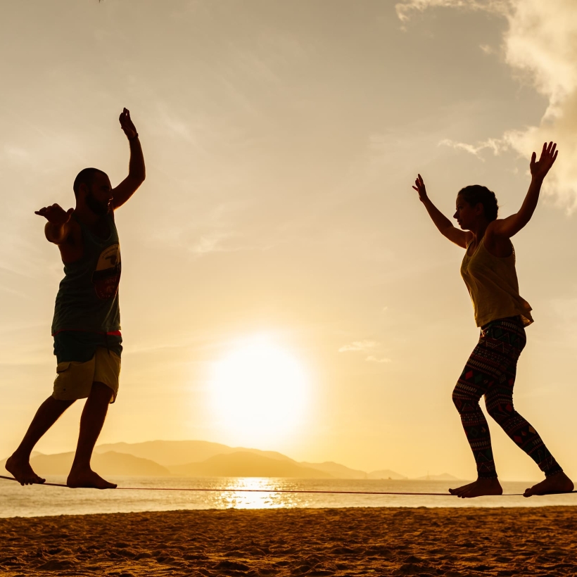 couple-balancing-slackline-on-the-beach-2021-04-05-10-03-50-utc