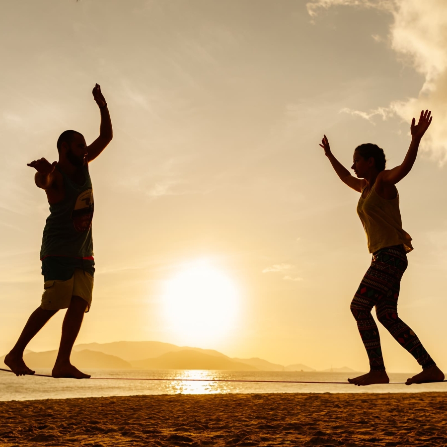 couple-balancing-slackline-on-the-beach-2021-04-05-10-03-50-utc